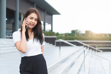 Young asian female student college calling someone on phone and looking to you.