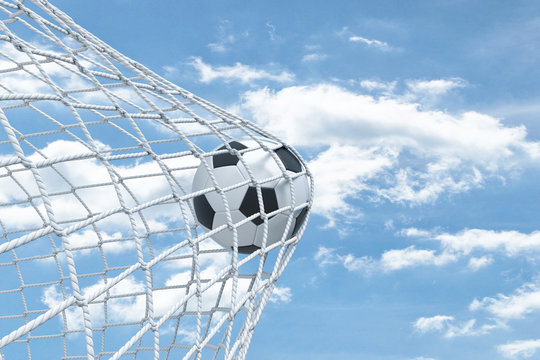 3d rendering of a football ball caught in a white net from the gates on a sky background.