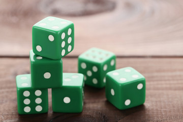 Green dice on brown wooden table