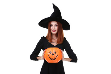 Beautiful redhaired woman in halloween costume with pumpkin bucket on white background