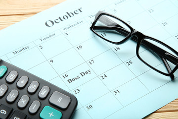 Inscription Boss Day in calendar with calculator and glasses