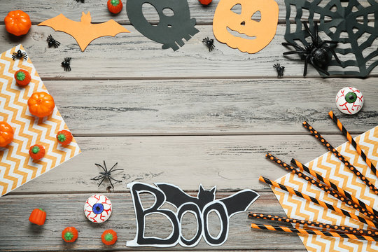 Halloween candies with paper decorations on wooden table