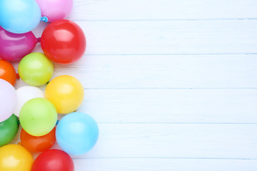 Fototapeta na wymiar Colorful balloons on white wooden table