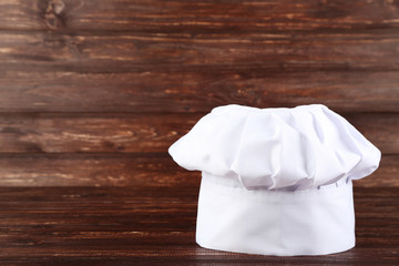 Chef hat on brown wooden table