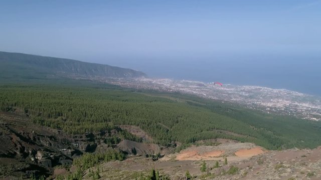 Aerial - Person paragliding over distant city