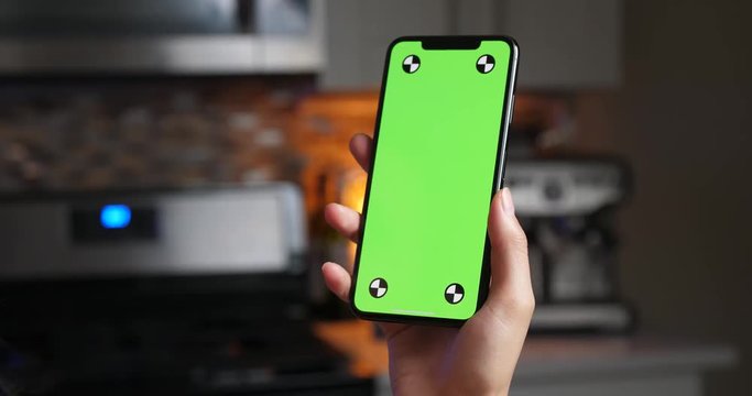 Woman holding green screen smartphone