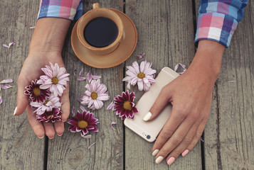hands with flowers and phone