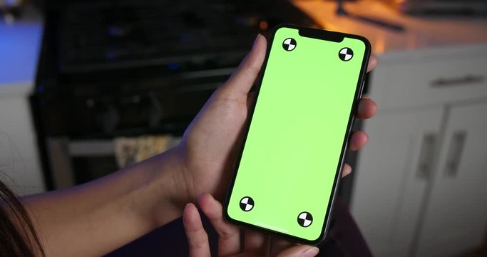 Woman holding green screen smartphone