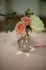 Minimalist Wedding Decor Centerpiece Pink and White Roses in a Glass Vase on a Table with a Pink Tablecloth