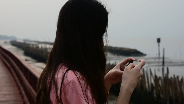 Women holding smartphone and using phone take photo travel on morning sunlight