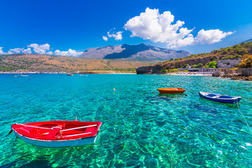 The gulf outside of the amazing caves of Dirou with fishing boats and turquoise waters, Peloponnese, Greece.