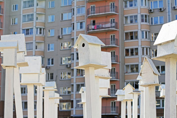 White birdhouses standing in front of an apartment building