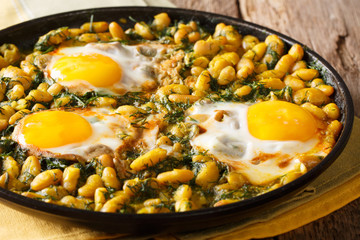 Iranian Baghali Ghatoghstew of beans and dill with fried eggs, garlic and turmeric close-up on a table. horizontal