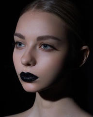 High Fashion Model Girl Portrait with Trendy gothic Black Make up, dark portrait. Halloween Vampire Woman with black matte lips over deep blue background. model girl face with black lipstick makeup.