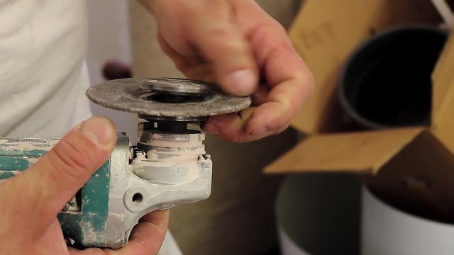 Man installing grinder disc, taking a new one out of backet and changing grinder disk to another, with handheld camera movement shake