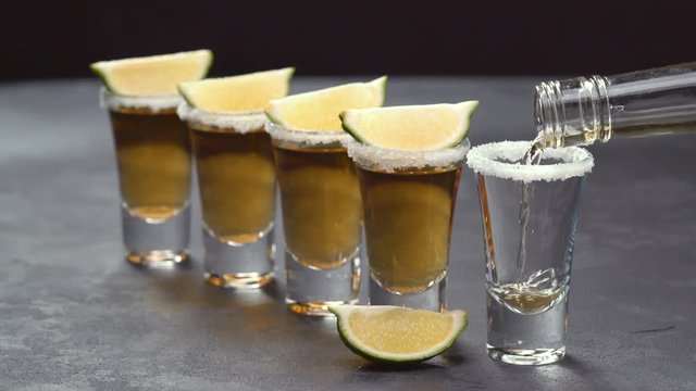 Pouring gold tequila on a black background ,selective focus