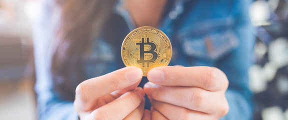 Woman hand holding a currency bitcoin.