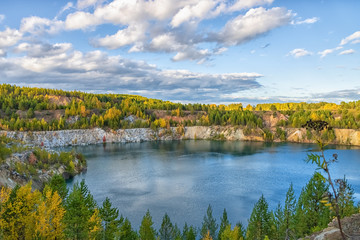 Autumn landscape with colourful forest around the lake. Beautiful autumn trees around the forest lake. The concept of hiking.