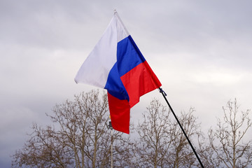 Russian flag-tricolour on the background of gray spring sky