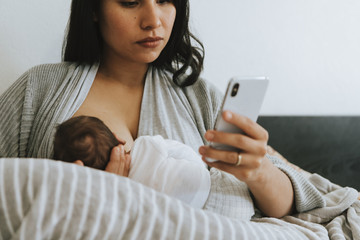 Breastfeeding mother using a smartphone