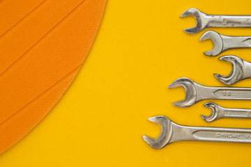 Tools for repair on plain yellow background