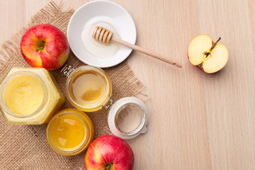 Jewish holiday Rosh Hashanah background with honey and apples on wooden table.