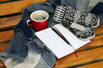 kawa i ciepłe ubrania na ławce w parku