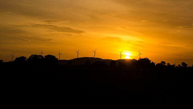 Wind Turbines On Hill At Sunset