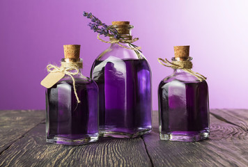 Obraz na płótnie Canvas Three glass jars with aromatic tincture of lavender