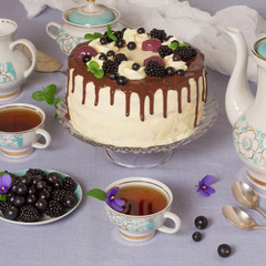 Festive table. Beautiful delicious cake with berries and hot herbal tea