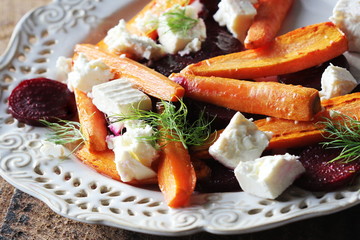 Healthy grilled beet, carrots salad with cheese feta, fennel on the rustic wooden table