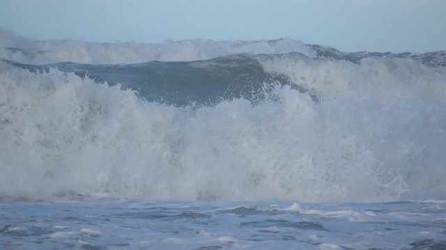 Waves rolling on the beach is a stormy day, winter mediterranean sea. Focene, Lazio, Italy. Slow motion