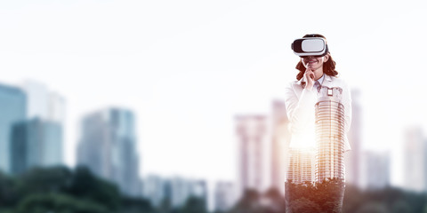 Fototapeta na wymiar Woman in mask against sunrise above city trying virtual reality