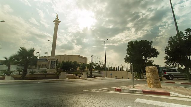 RAMALLAH, WEST BANK - TIMELAPSE. Traffic drives over a roundabout in central Ramallah with clouds in the sky, West Bank. 4K