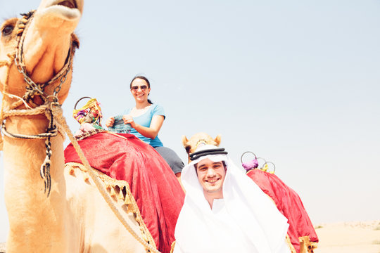 Arabian Man And Tourist Riding A Camel