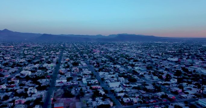 La Paz Mexico Drone Aerial 4K Slow Pan Left to Right over City and Harbor Bay Marina at Dusk with Sunset near End