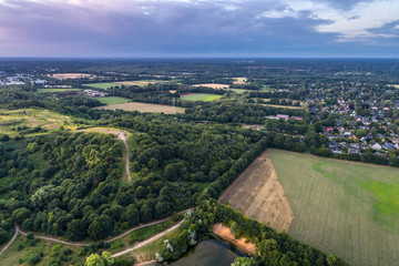 Aerial view of amazing sunset over the park in Germany. Hill and lake from birds eye view.  