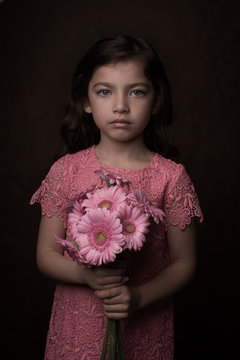 Portrait of girl with bouquet of pink gerberas
