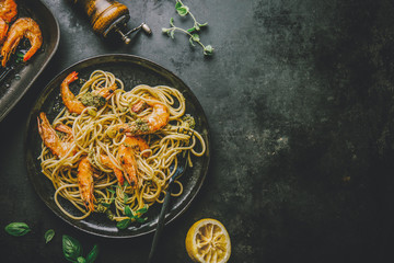 Spaghetti with pesto and prawns served on plate