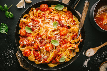 Tasty appetizing spaghetti with tomato sauce and cheese on pan on table. View from above. Horizontal with copy space. 