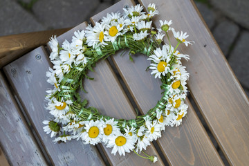 A crown of daisies also known as bellis perennis on a chair © Janisphoto
