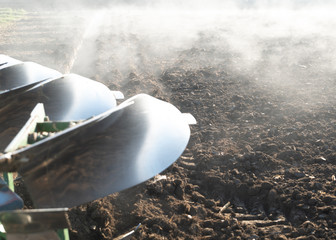 Pflug fährt übers Feld und der Nebel steigt auf