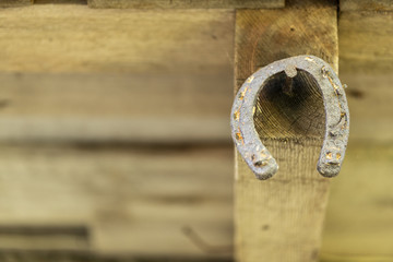 A rusty horseshoe hanging on a wood wall