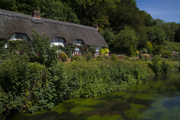 Fototapeta na wymiar Thatched Cottage beside the River Test, Wherwell, Hampshire, England.