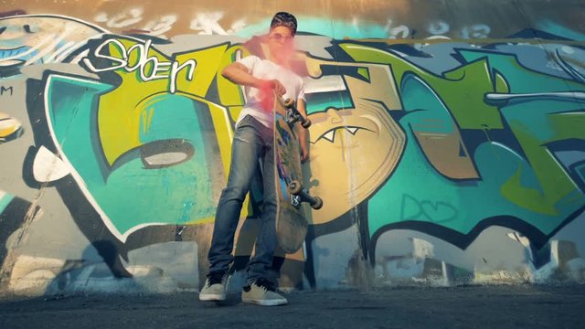 One skater flips a board and catches it, slow motion.
