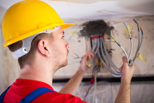 Electrician inspecting cables and wires