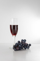 glass of the grape wine with grape branch on the white backround