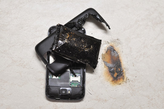 Mobile phone battery explodes and burns due to overheat. Danger, exploded mobile phone battery