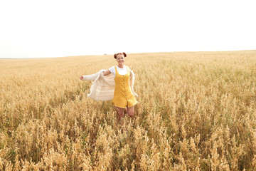 girl with red hair in the autumn field of wheat