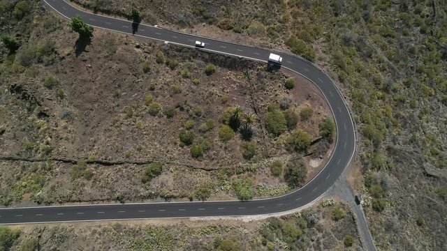 Aerial - Top down static shot of van and car driving a on road curve